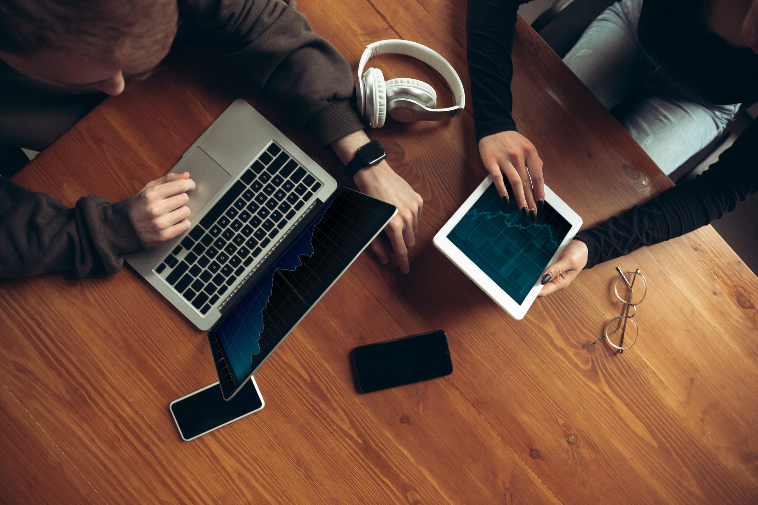 Attractive surprised and amazed couple using devices together, tablet, laptop, smartphone, headphone wireless. Communication, technologies, gadgets, having fun concept. Lifestyle at home.