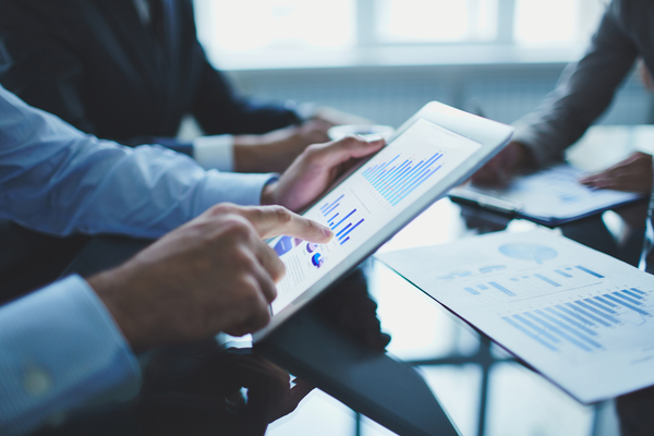 Image of businessperson pointing at document in touchpad at meeting