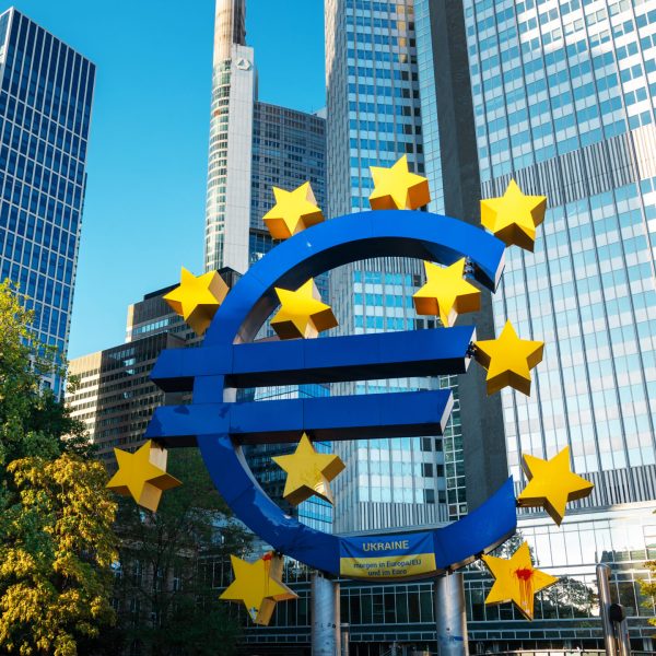 Close view of The Euro-Skulptur with multiple skyscrapers on the background in Frankfurt downtown, Germany. Flag of Ukraine and blood on it