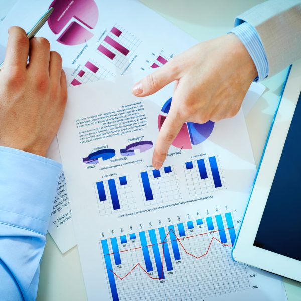 Close-up of female hand pointing at business document while explaining chart